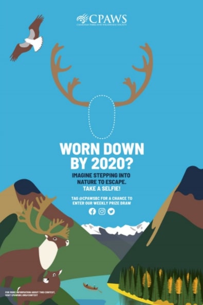 ID: Illustrated poster with window for face. Blue skies, mountain and caribou antlers.