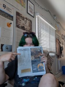 Siya holding up the first ad instalment of the Weird and Wonderful BC in the Merritt Herald